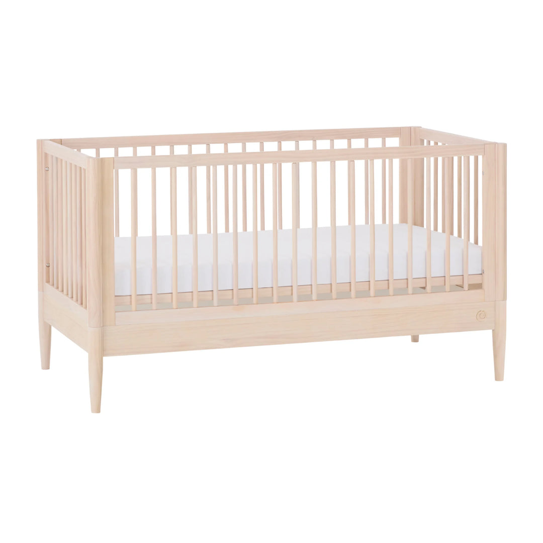 Gaia Baby Eos convertible cot in all-natural wood finish, solid wooden baby crib shown at an angle on a white background