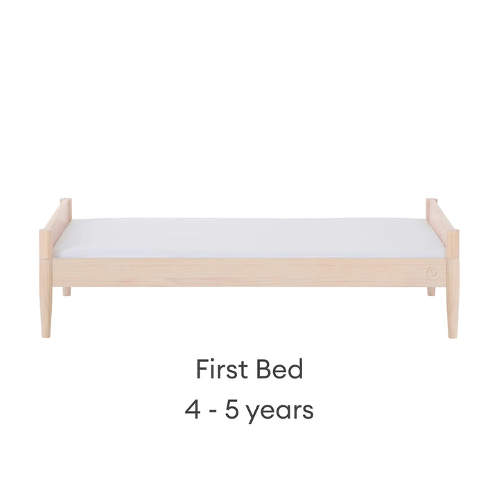 Gaia Baby Eos convertible cot transformed into first bed for ages 4–5 years in all-natural wood finish on a white background
