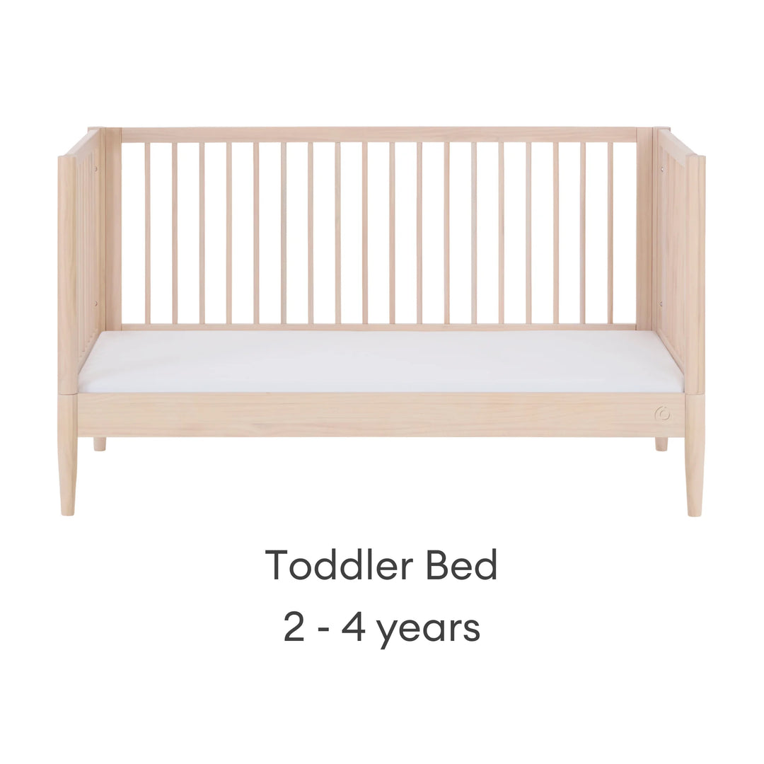 Gaia Baby Eos convertible cot transformed into toddler bed for ages 2–4 years in all-natural wood finish on a white background.