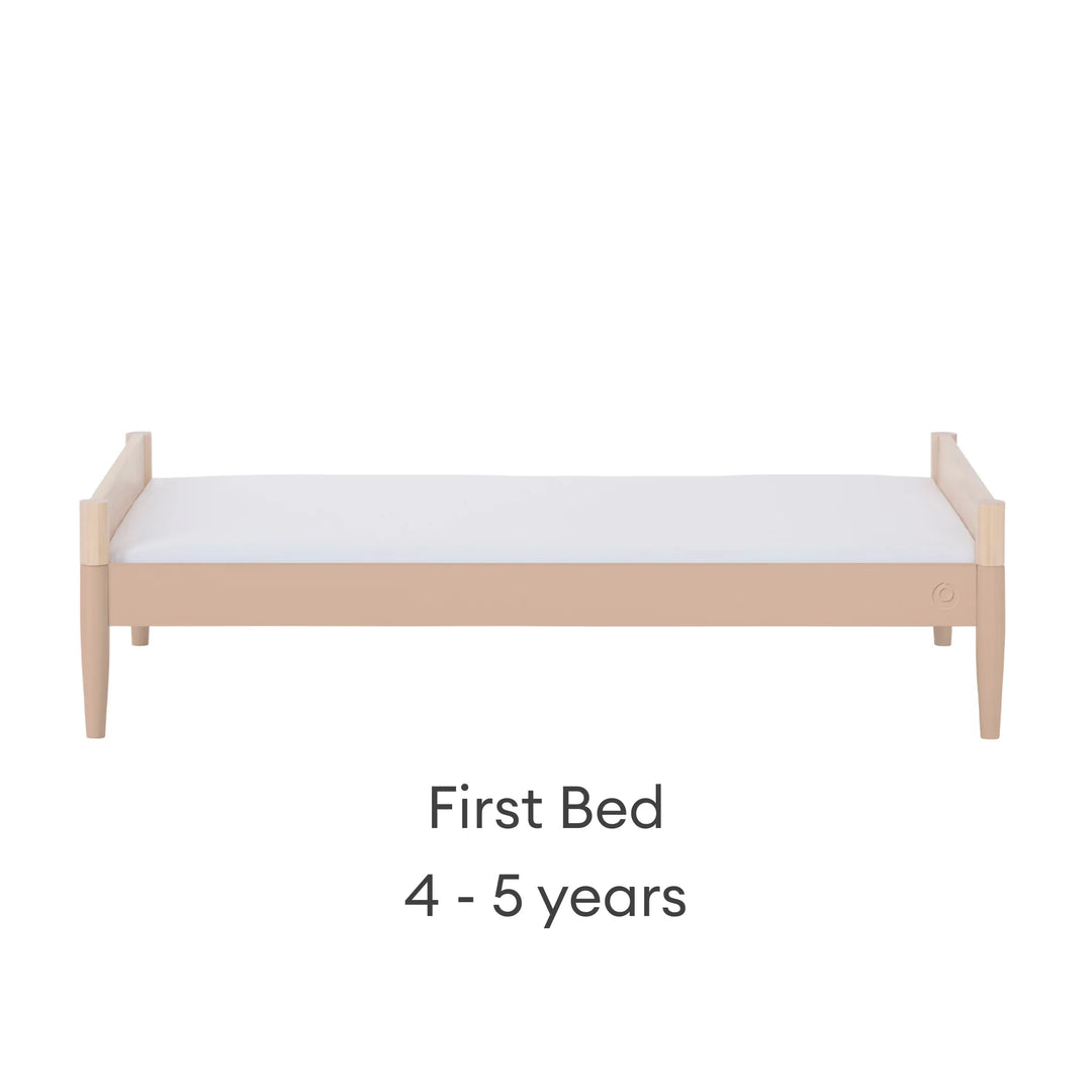 Gaia Baby Eos convertible cot transformed into first bed in natural wood and powder blush finish for ages 4–5 years on a white background.