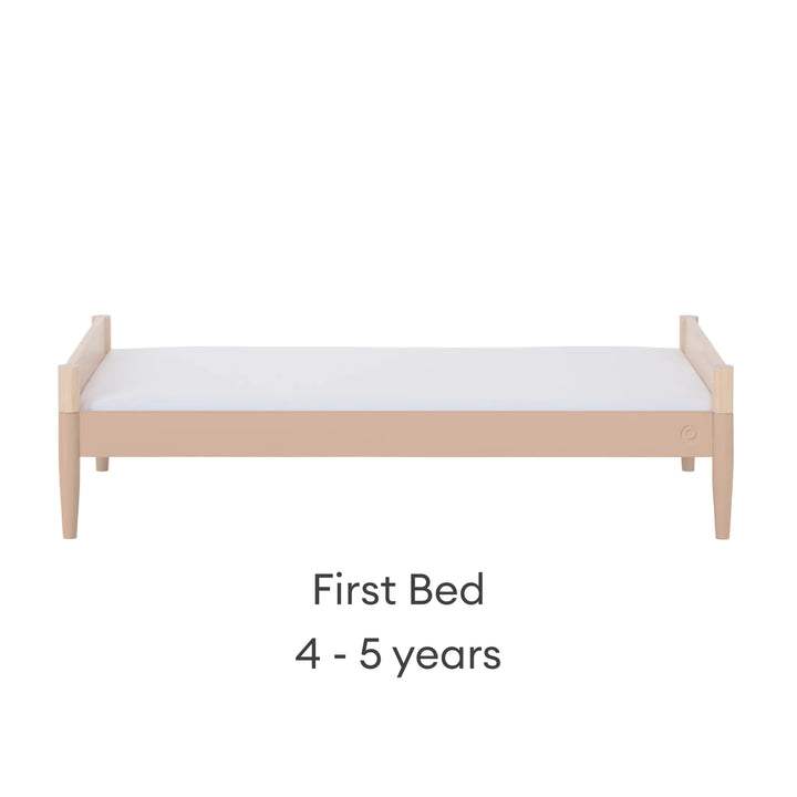 Gaia Baby Eos convertible cot transformed into first bed in natural wood and powder blush finish for ages 4–5 years on a white background.