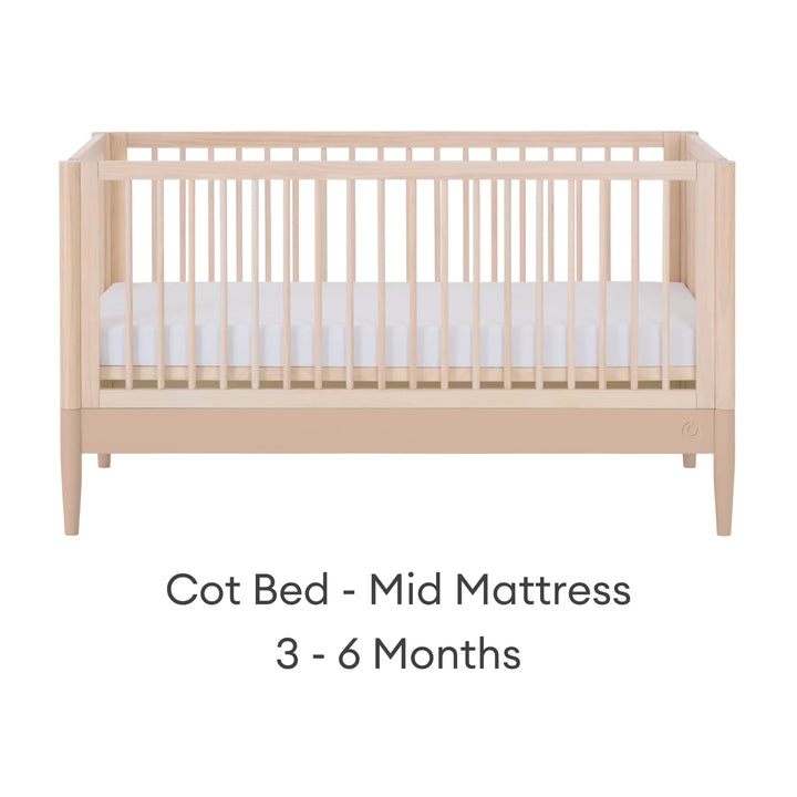 Gaia Baby Eos convertible cot in natural wood and powder blush finish with mattress in mid position for 3–6 months on a white background.