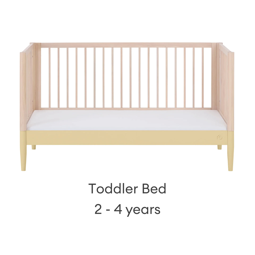 Gaia Baby Eos convertible cot bed in natural wood and yellow converted to toddler bed with white mattress (2–4 years)
