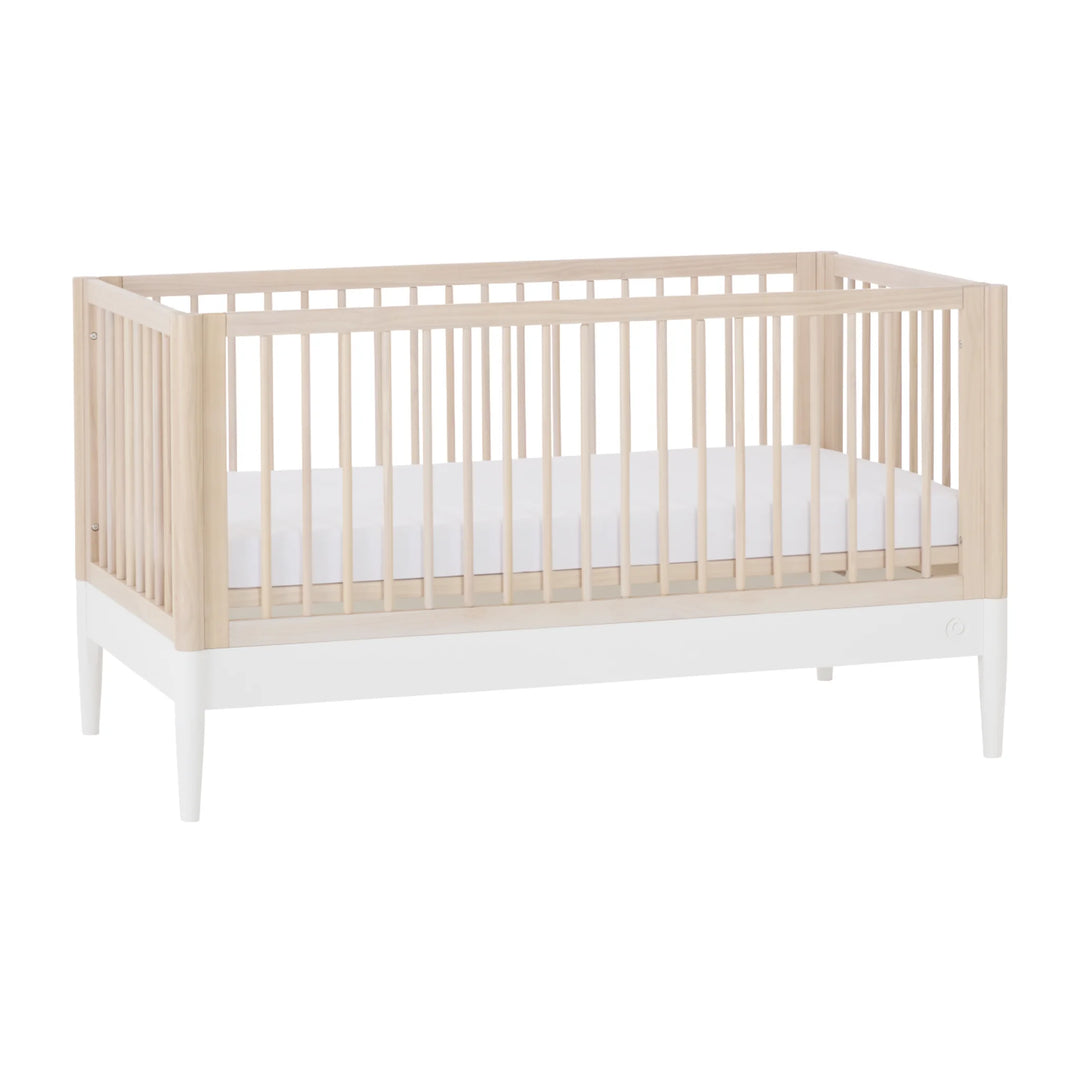 Gaia Baby Eos convertible cot in natural wood and white finish with mattress on white background