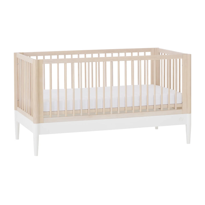 Gaia Baby Eos convertible cot in natural wood and white finish with mattress on white background