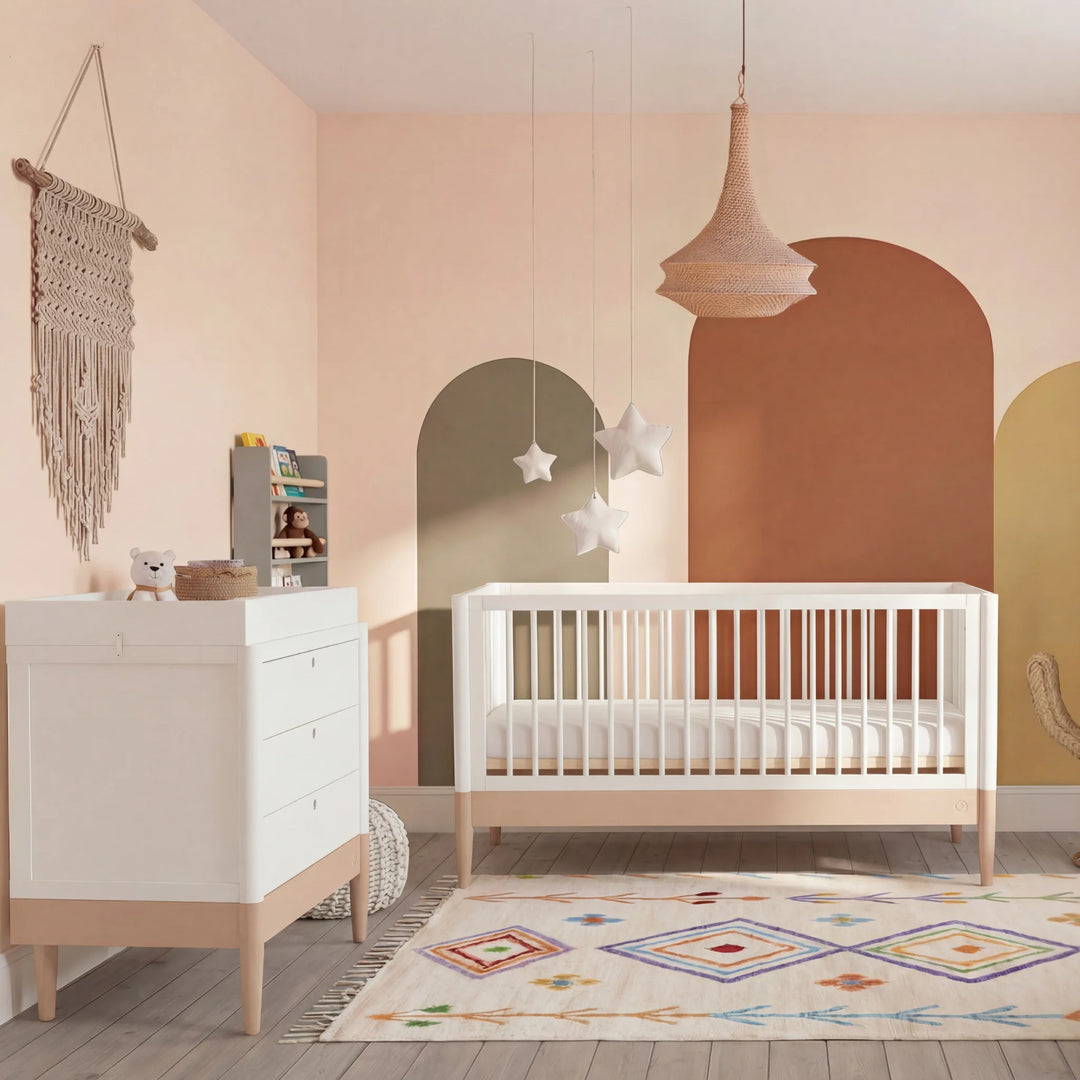 Gaia Baby Eos cot bed and dresser set in white and natural wood styled in powder blush nursery with colourful rug