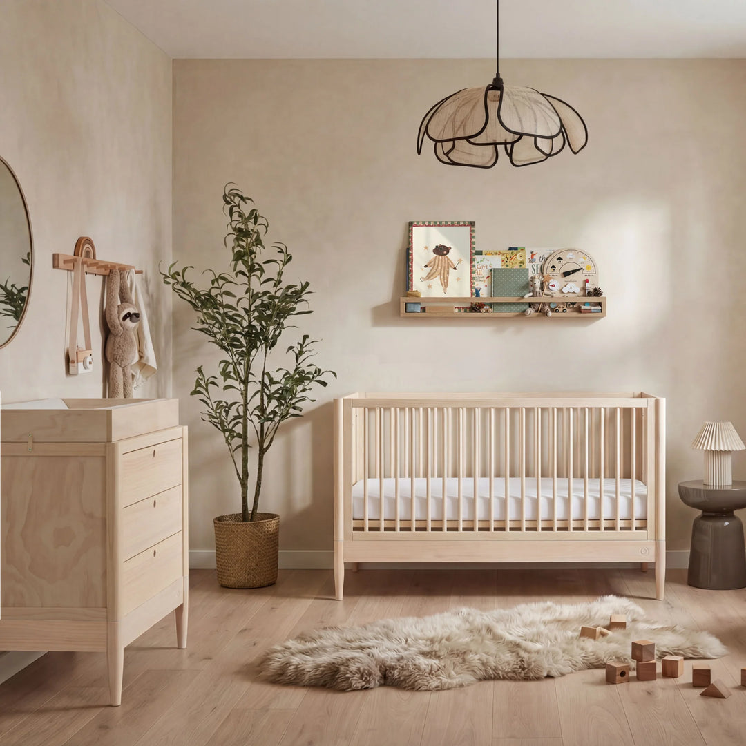 Gaia Baby Eos convertible cot and dresser set in natural wood styled in a modern neutral nursery room