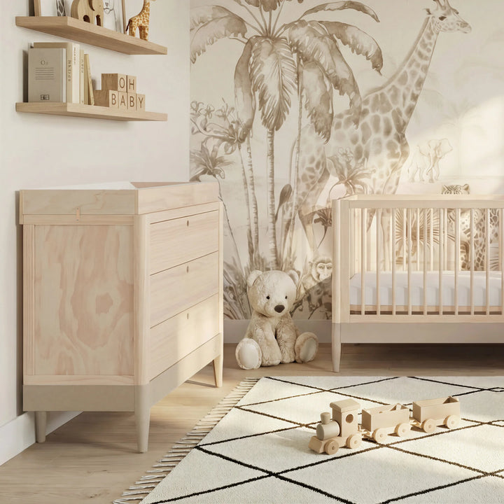 Gaia Baby Eos dresser and cot in natural wood styled in safari nursery with giraffe wallpaper and neutral tones