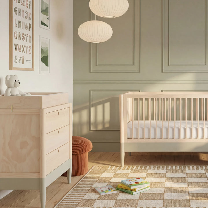Gaia Baby Eos dresser with changing top in natural wood and desert sage in a modern nursery with cot and soft neutral decor