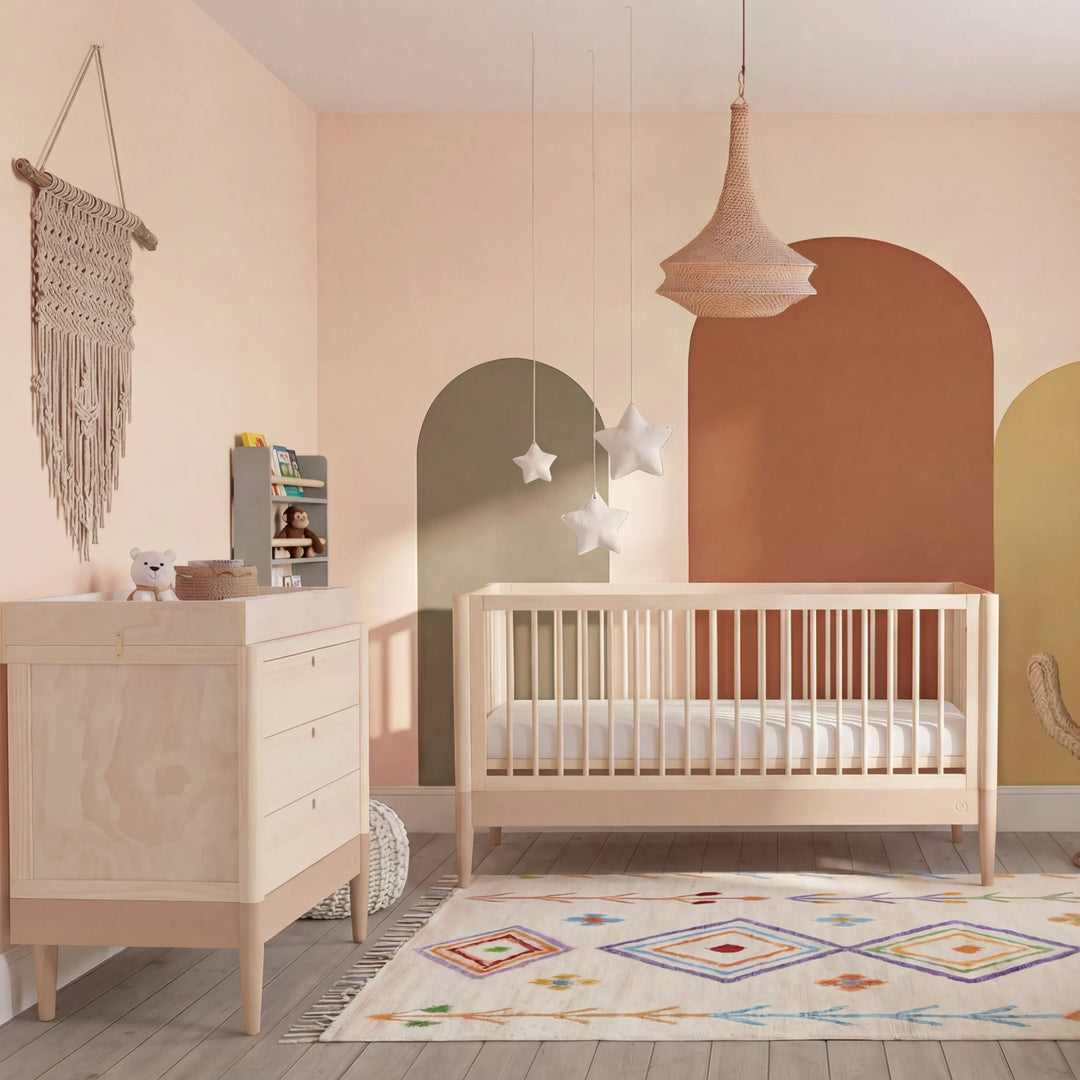 Gaia Baby Eos dresser and cot in natural wood styled in blush nursery with arched wall design and warm tones