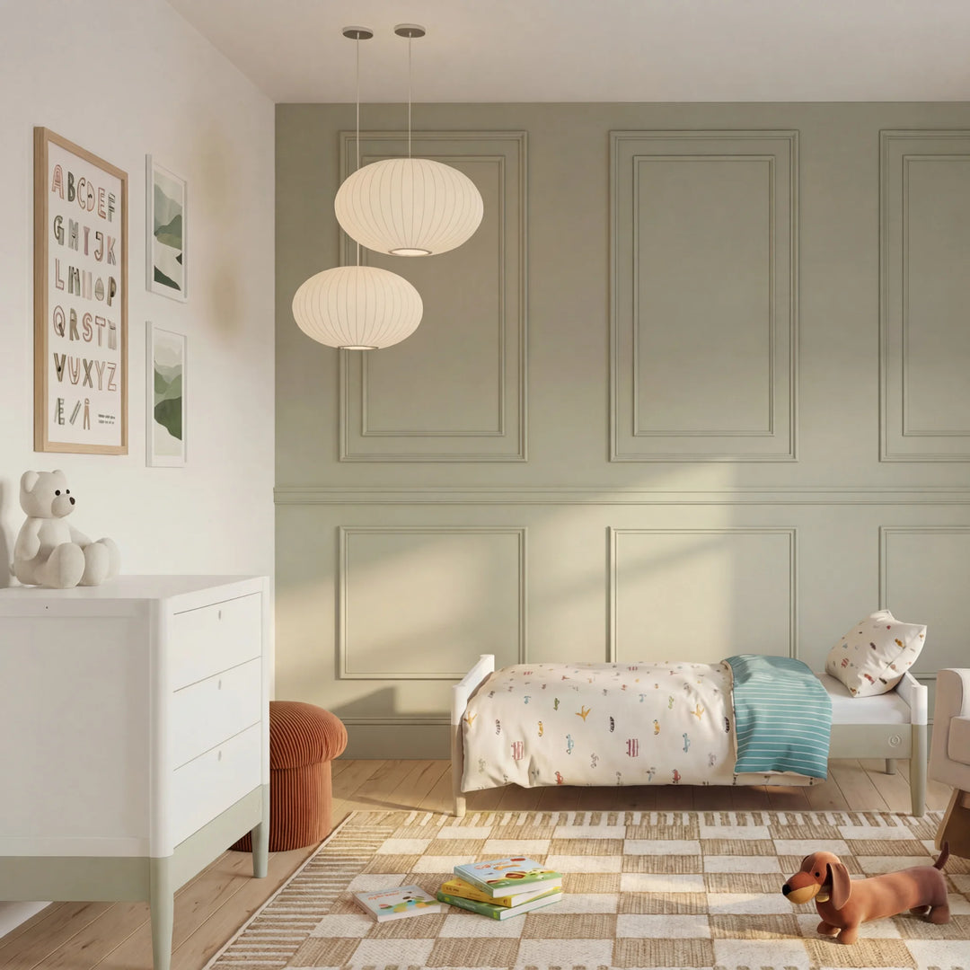 Gaia Baby Eos dresser with changer in white and desert sage in a nursery with toddler bed and toys