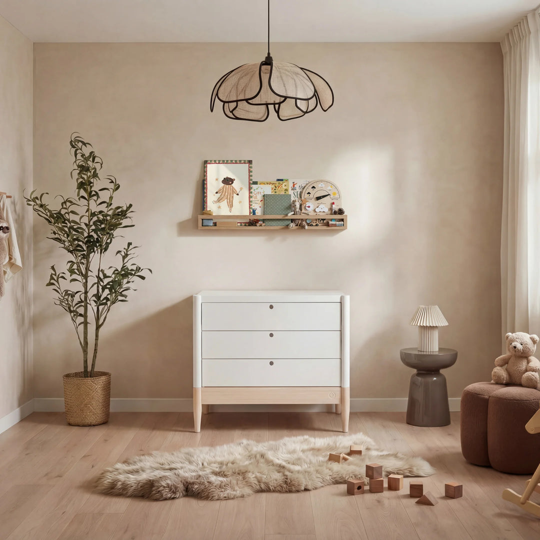 Gaia Baby Eos dresser in white and natural wood in a neutral nursery with plant, shelf, and toys