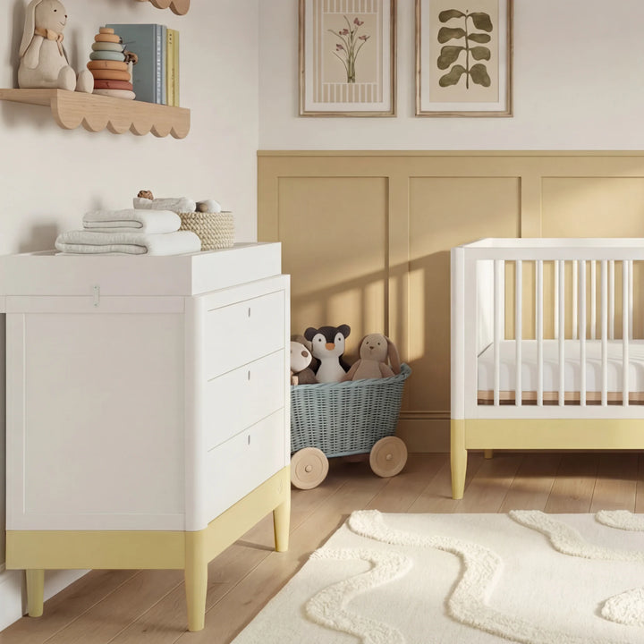 Gaia Baby Eos dresser in white and primrose yellow with changing top in nursery with matching crib and toys