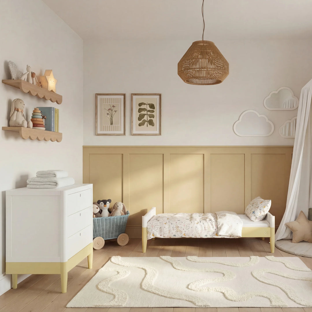 Gaia Baby Eos dresser in white and primrose yellow with changing top in nursery with matching crib and toys