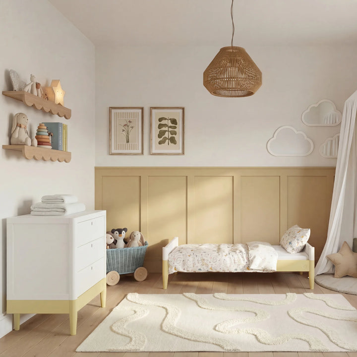 Gaia Baby Eos dresser in white and primrose yellow with changing top in nursery with matching crib and toys