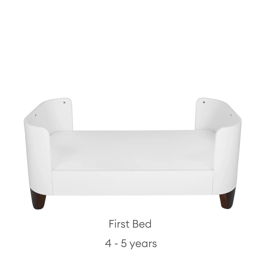 Serena Cot Bed with walnut legs on white background with text: First Bed, 4 - 5 years.