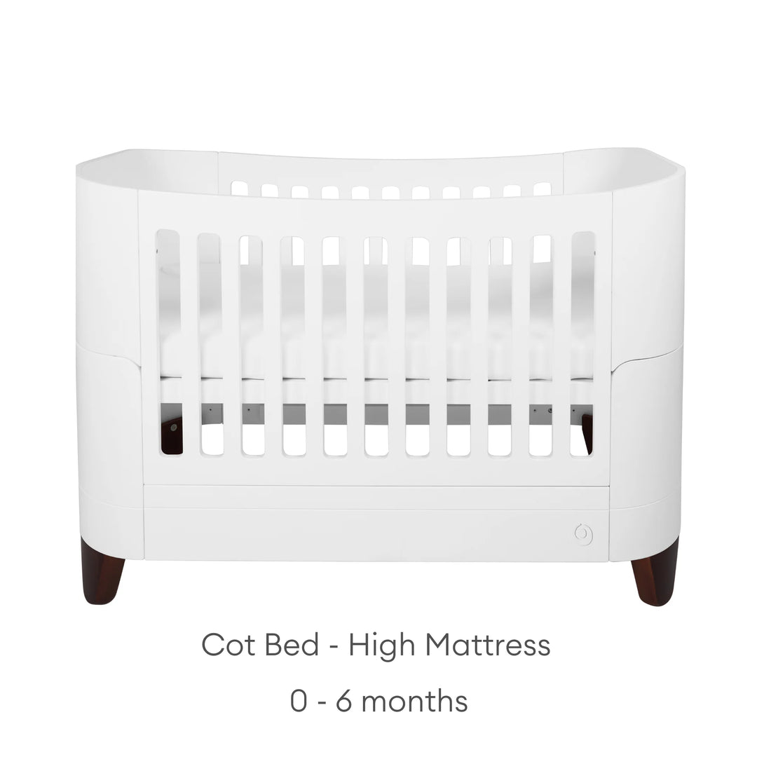 Serena Cot Bed with walnut legs on white background with text: Cot Bed - High Mattress, 0 - 6 months.