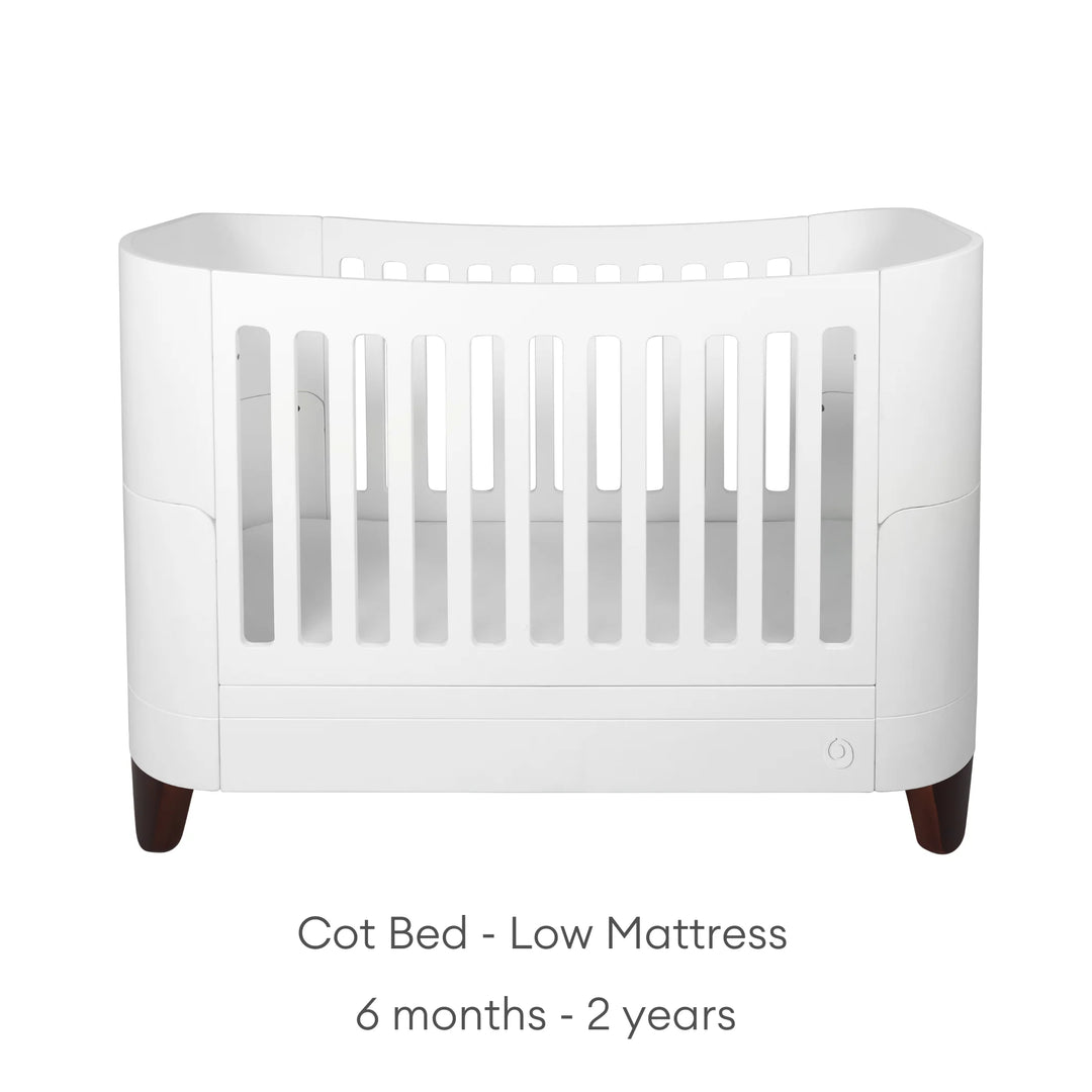 Serena Cot Bed with walnut legs on white background with text: Cot Bed - Low Mattress, 6 - 12 months.