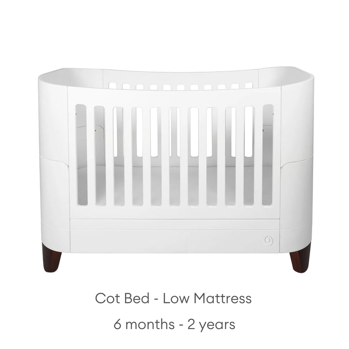 Serena Cot Bed with walnut legs on white background with text: Cot Bed - Low Mattress, 6 - 12 months.