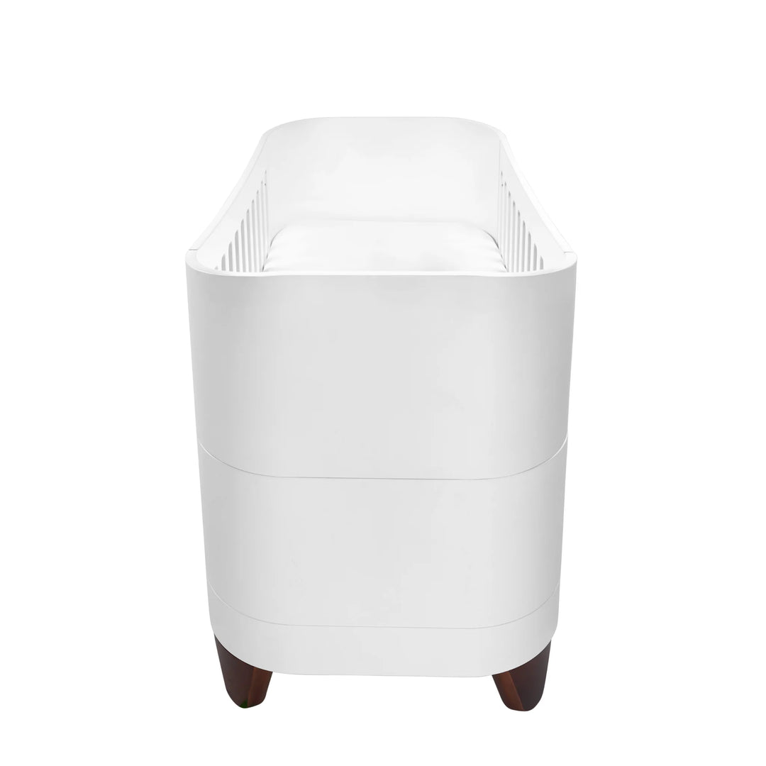 Serena Cot Bed with walnut legs side shot on white background.