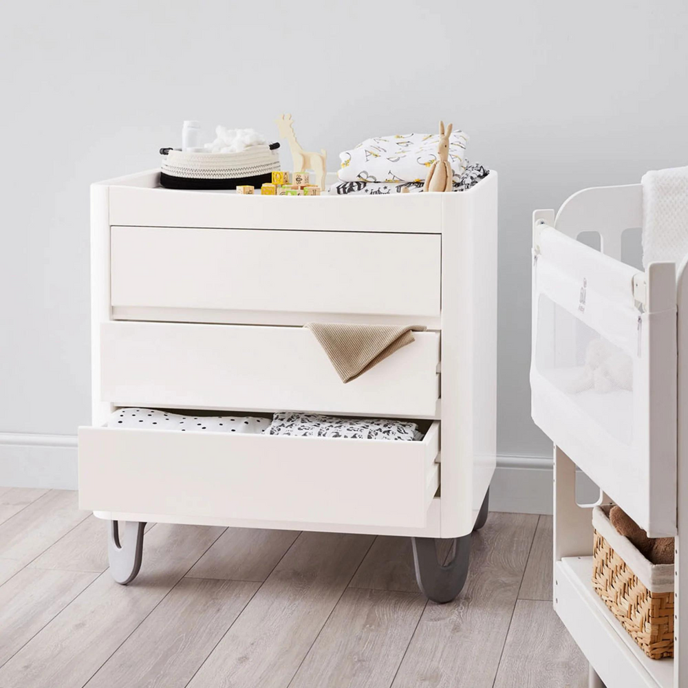 This image shows the Serena Dresser in a nursery with blankets on top and in the drawers.