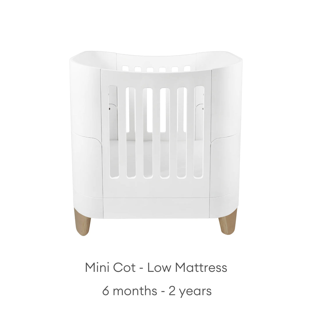 Real wood baby cot with text: mini cot - low mattress: 6 months - 2 years.