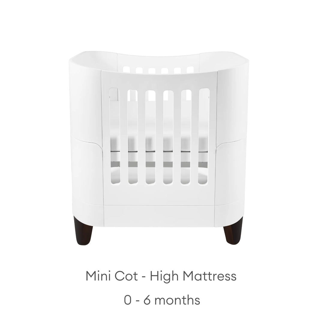 Serena Mini Cot with walnut legs with text: high mattress - 0 - 6 months.
