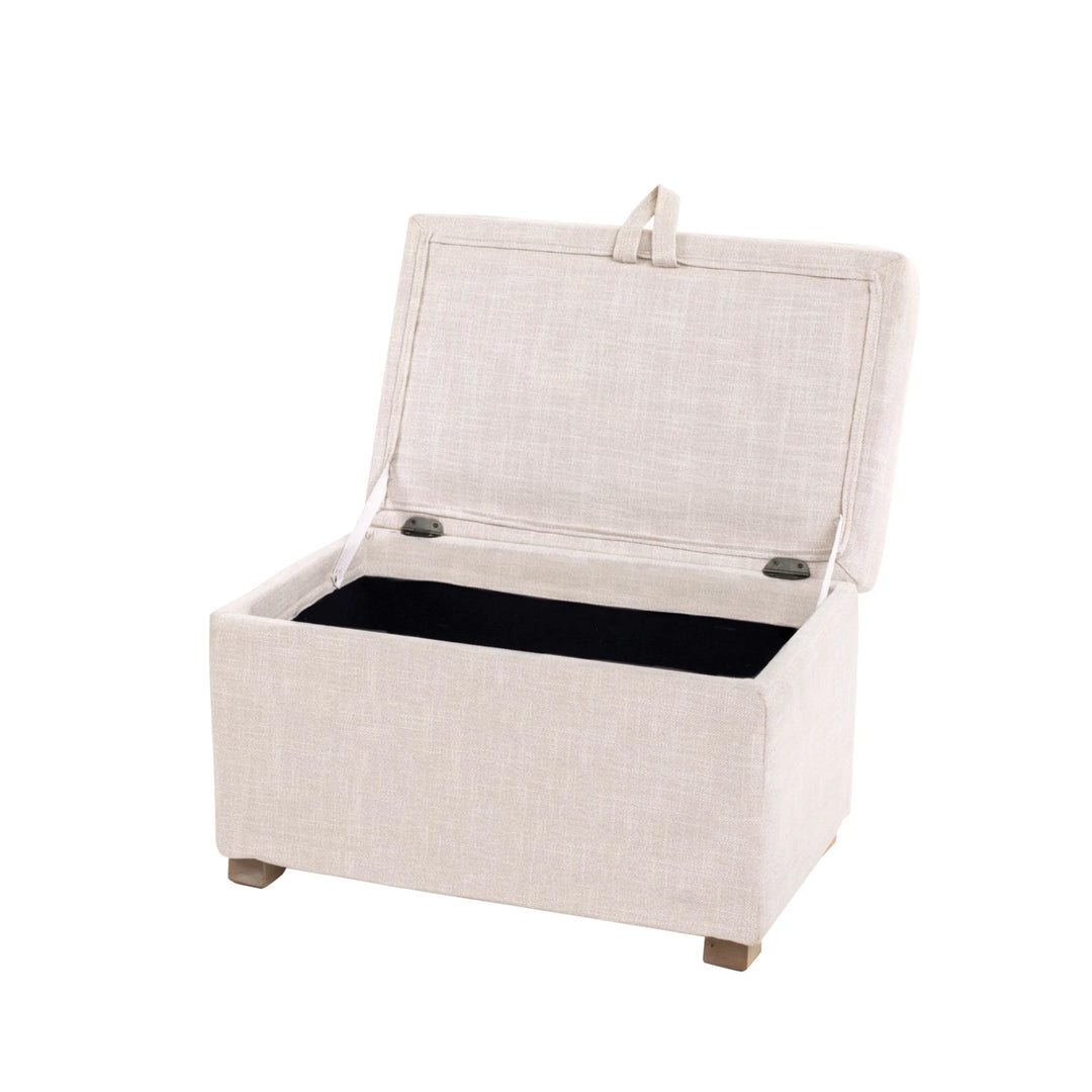 The Gaia Baby Serena Footstool in oat fabric shown at an angled view with the lid open on a white background, featuring a soft upholstered storage ottoman with a spacious interior compartment and light wooden feet.