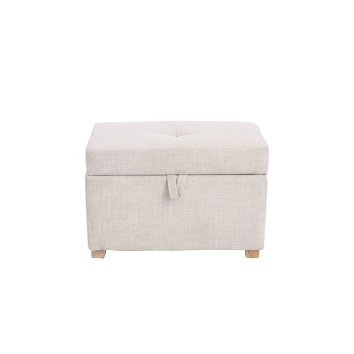 The Gaia Baby Serena Footstool in oat fabric shown from the front on a white background, featuring a soft upholstered storage ottoman with a pull-tab lid detail and light wooden feet.