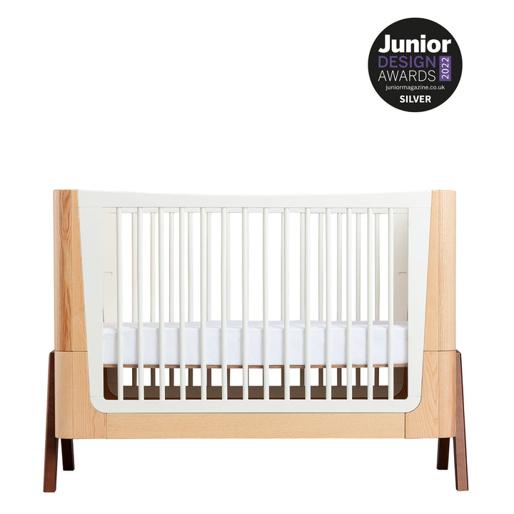 Hera Cot Bed in Natural Ash and Walnut with a Junior Design Award 2022 silver logo
