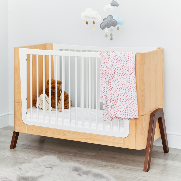 lifestyle image of Hera Cot Bed in Natural Ash and Walnut on low mattress setting