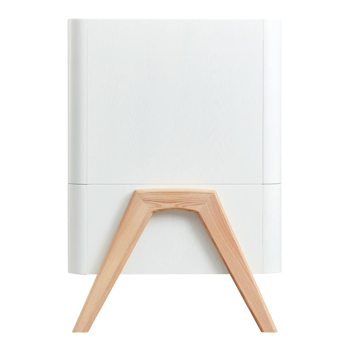 Side view of Gaia Baby Hera cot bed in Scandi White with natural solid wood A-frame legs, showcasing curved Scandinavian design and premium sustainable nursery furniture craftsmanship.