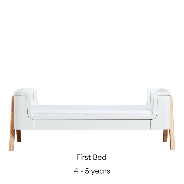 Gaia Baby Hera Cot Bed in Scandi White and Natural. Image shows the cot bed as transformed into a first bed that is suitable for four to five year old child