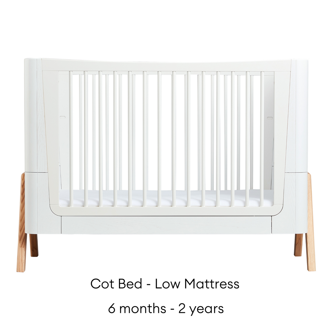 Gaia Baby Hera Cot Bed in Scandi White and Natural. Shows Cot Bed in the low mattress settings that is suitable for babies aged six months to two years