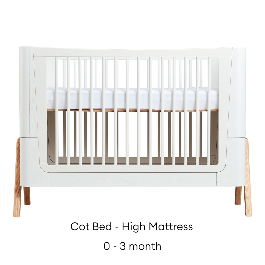 Gaia Baby Hera Cot Bed in Scandi White and Natural. Shows Cot Bed with High Mattress level that is suitable from newborn to three months
