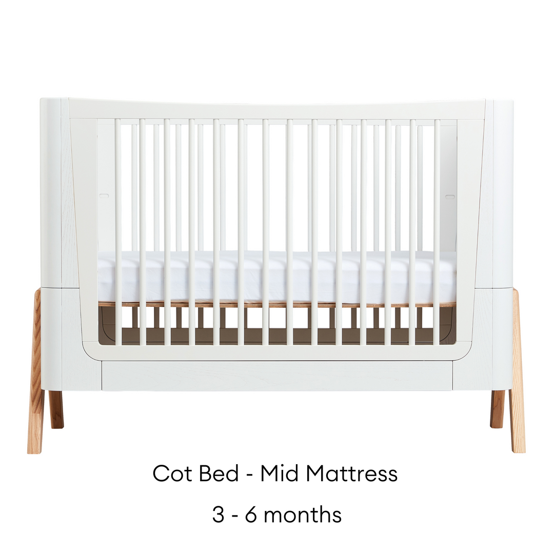 Gaia Baby Hera Cot Bed in Scandi White and Natural. The image shows the Cot Bed with Mid Mattress level that is suitable for babies ages three to six months