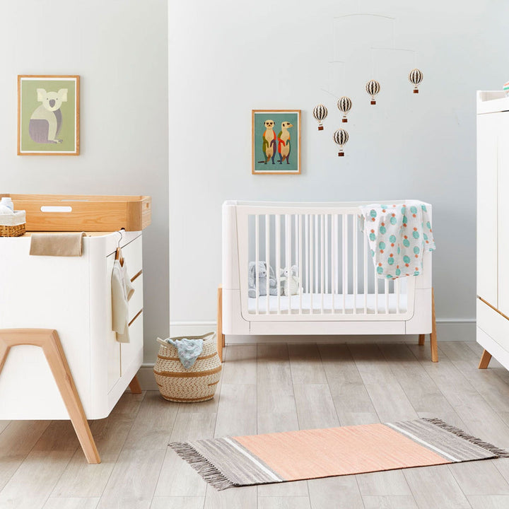 Gaia Baby Lifestyle image of the Hera Cot Bed in Scandi White and Natural with the low cot bed mattress setting