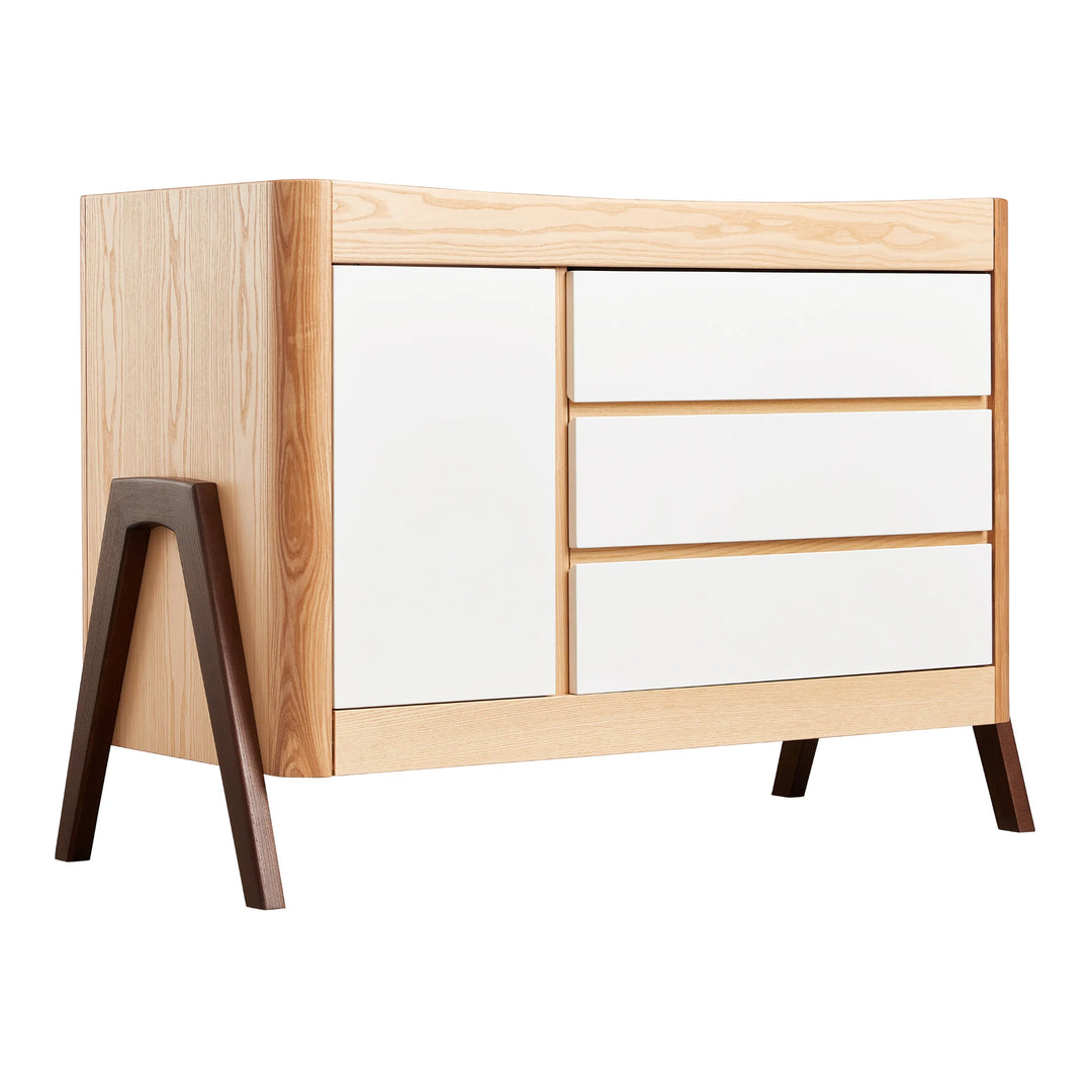 Gaia Baby Hera dresser in ash and walnut finish, featuring Scandinavian modern design with white drawers, natural wood frame, and angled solid walnut legs — premium sustainable nursery furniture.
