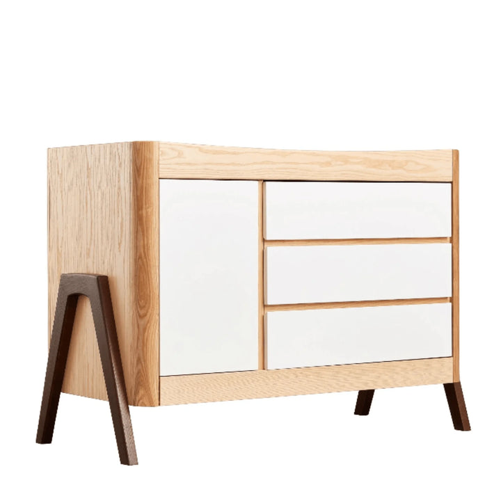 Gaia Baby Hera dresser in Scandi white with natural ash and walnut accents, modern three-drawer nursery dresser featuring minimalist Scandinavian design and contrasting solid wood legs.