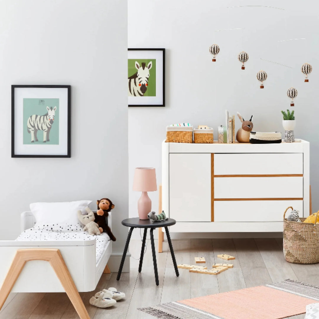Modern nursery featuring the Gaia Baby Hera dresser in Scandi white and natural wood, styled with matching toddler bed, wall art, toys and décor to showcase minimalist Scandinavian design.