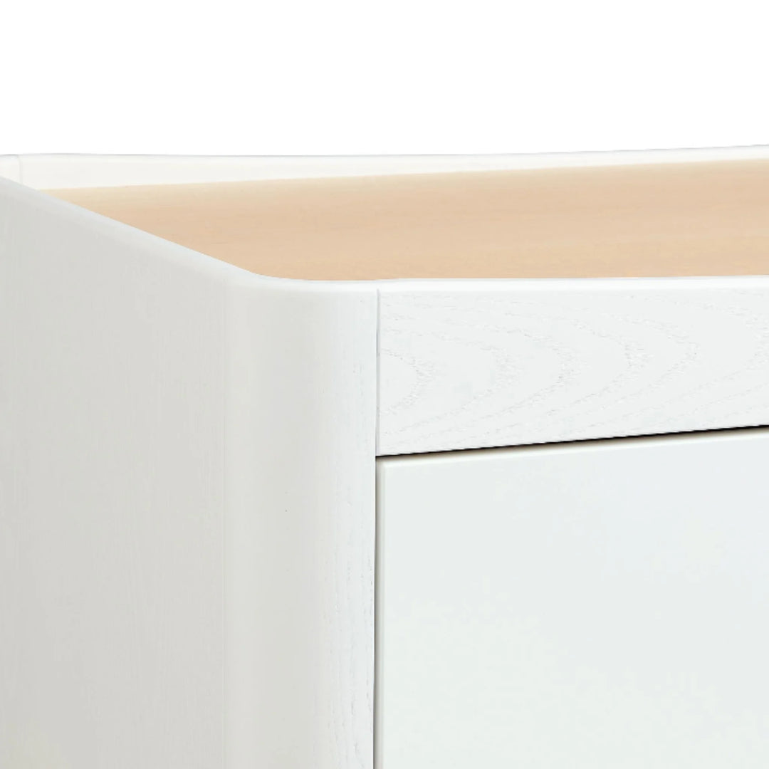 Close-up of the Gaia Baby Hera dresser in Scandi white and natural wood, highlighting the solid ash A-frame leg design and smooth curved edge detailing.