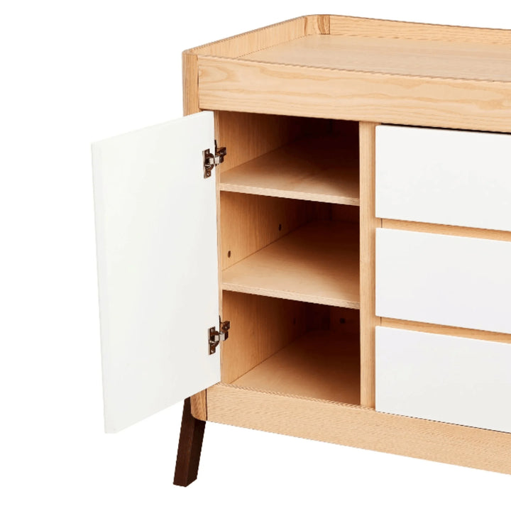 Gaia Baby Hera dresser in Scandi white and natural wood shown open, featuring adjustable internal shelving and smooth soft-close door design alongside three spacious drawers.”