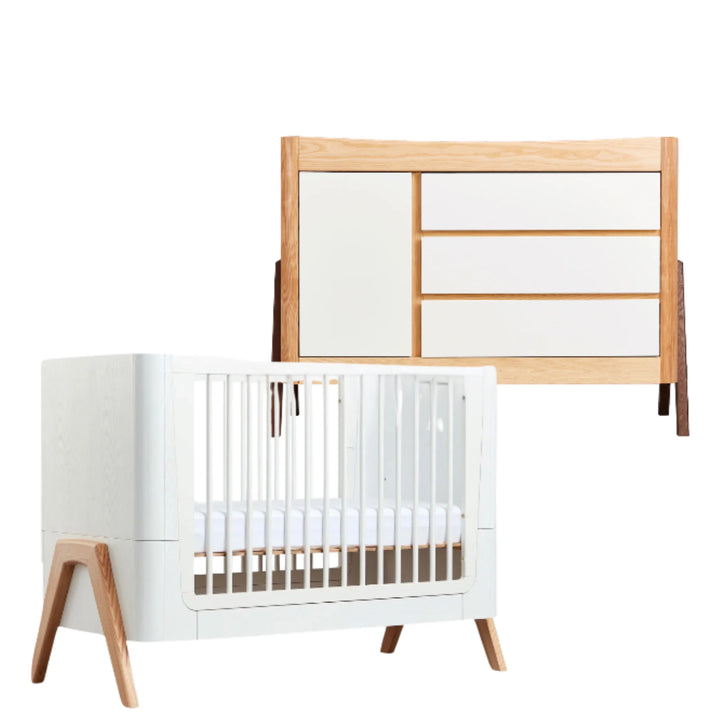 Gaia Baby Hera dresser and cot set in Walnut Ash, featuring a modern white dresser with natural walnut-ash wood frame and matching white Hera cot bed with angled wooden legs and slatted sides; premium Scandinavian-inspired eco-friendly nursery furniture for contemporary baby room design.