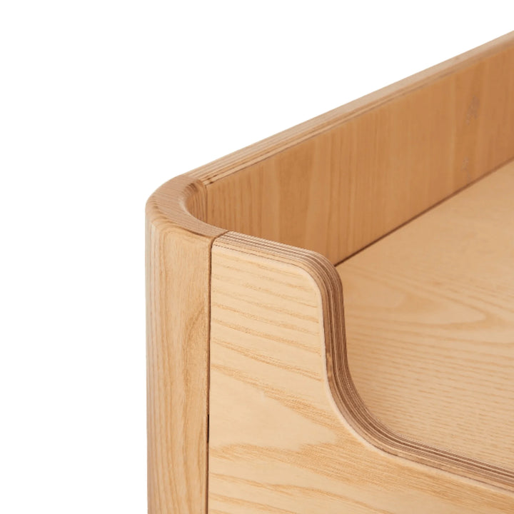 Close-up of the Gaia Baby Hera wardrobe in Natural Ash and Walnut showing smooth rounded corner detailing, solid ash wood grain and premium craftsmanship in Scandinavian nursery furniture.