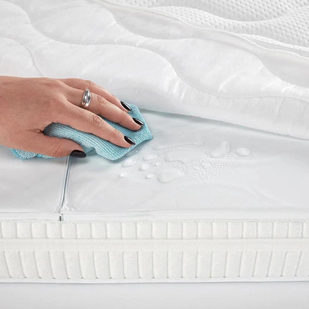 Gaia Baby Serena cot bed mattress with waterproof wipe-clean cover being cleaned