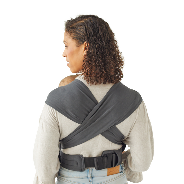 This image is a back shot of the carrier on a mother with the wide shoulder straps spread over her shoulders to evenly distribute the weight