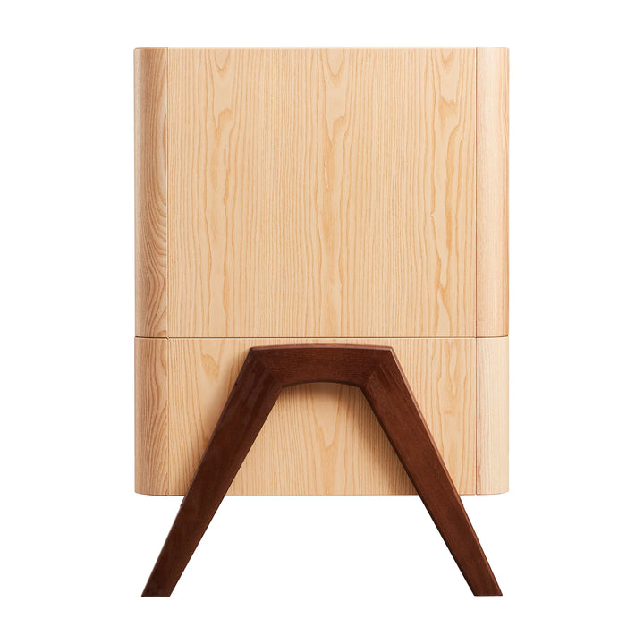 Side end view of the Gaia Baby Hera cot in ash and walnut, showcasing natural wood grain panels, solid walnut A-frame legs and smooth curved Scandinavian design — premium sustainable nursery furniture.