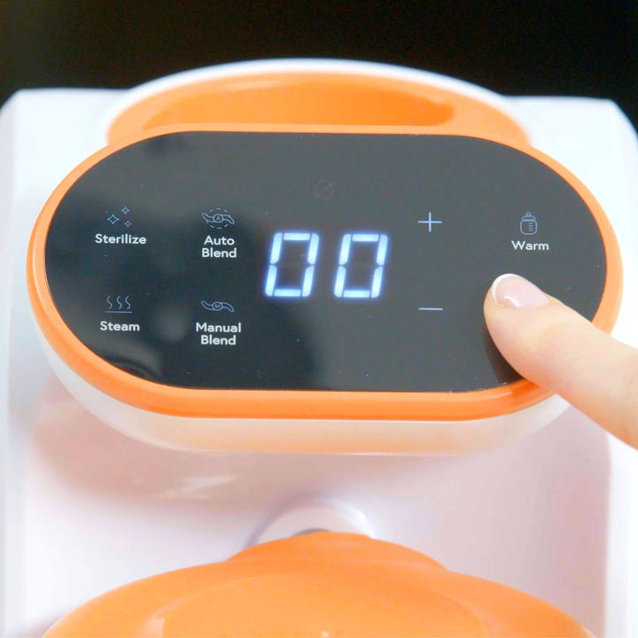 Close-up of digital control panel on Quook by Quark 5-in-1 baby food maker — touchscreen display showing steam, blend, warm, and sterilize functions for easy homemade baby meal preparation