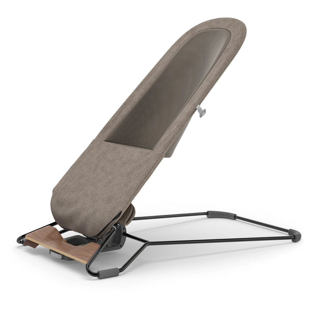 UPPAbaby Mira Bouncer in Wells taupe shown in upright mesh-back configuration, highlighting breathable ergonomic seat design, sleek lightweight steel frame, and walnut-tone wood base for modern baby bouncer functionality.”