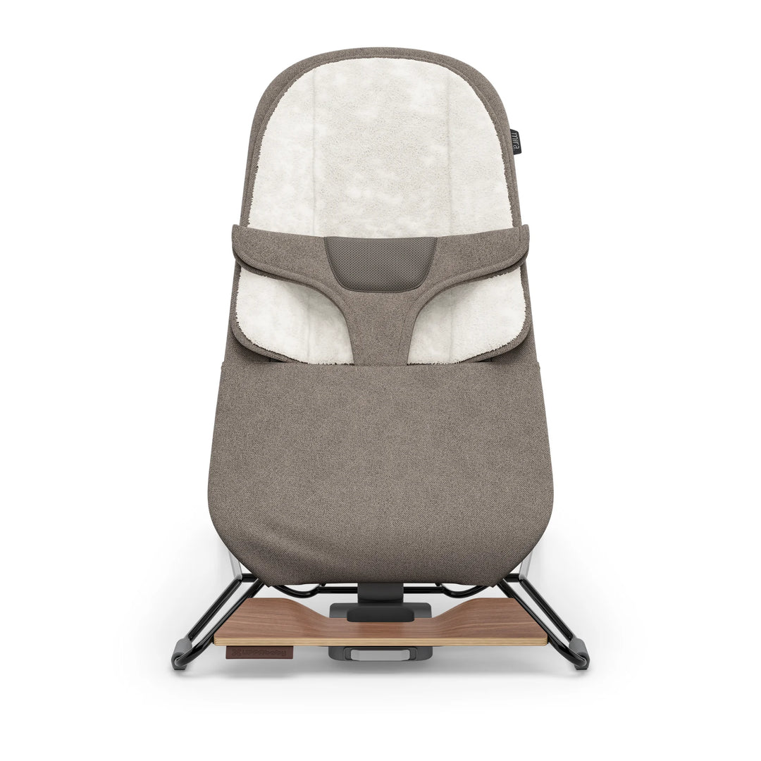 “UPPAbaby Mira Bouncer in Wells taupe shown front-facing on a white background, featuring plush newborn insert, breathable mesh support panel, ergonomic infant harness, and modern lightweight steel frame with walnut-tone wood base accent.”
